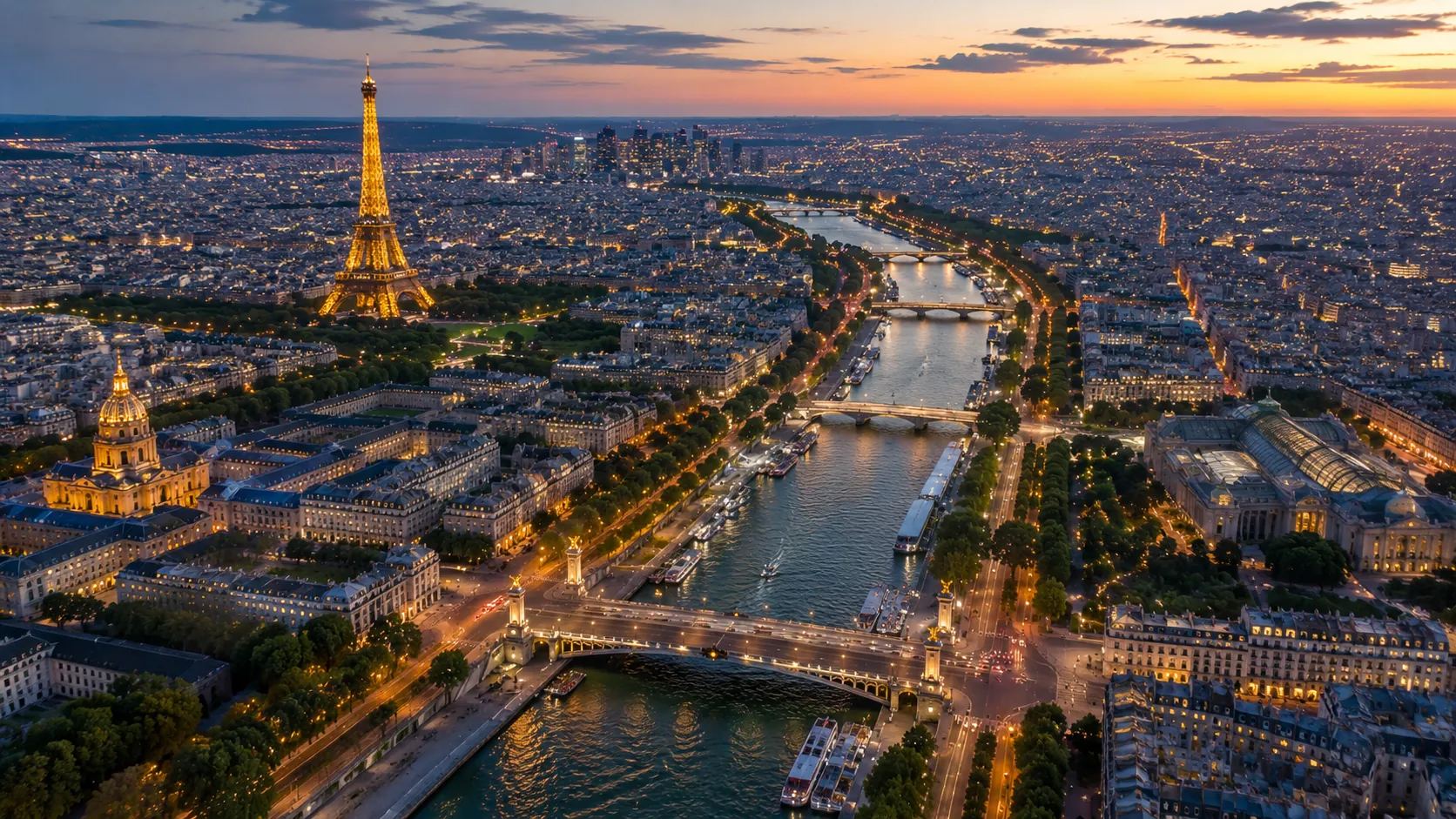 An aerial view of Paris at dusk, with the Eiffel Tower lit up beside the Seine